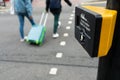 Close up of yellow metal crosswalk button for pedestrian crossing signal in London, UK for traffic rules. Two peoples crossing Royalty Free Stock Photo