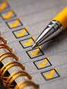 Close-up of a yellow pen marking completed tasks with bright checkmarks in a spiral-bound notebook checklist on textured paper Royalty Free Stock Photo
