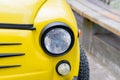 Close up of yellow retro car with round headlights Royalty Free Stock Photo