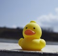 Close up of yellow rubber duck over sky created using generative ai technology Royalty Free Stock Photo