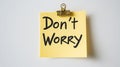 Close-up of Yellow Sticky Note with Don t Worry Message, Minimalist Concept on White Background. Royalty Free Stock Photo