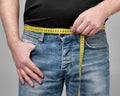 Man measuring waistline with yellow tape measure Royalty Free Stock Photo