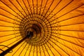 Close up of a yellow traditional burmese parasol, view from inside, asian background