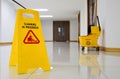 Close up yellow warning sign with message Cleaning in progress with cleaning trolley background Royalty Free Stock Photo