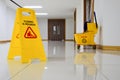 Close up yellow warning sign with message Cleaning in progress with cleaning trolley background Royalty Free Stock Photo