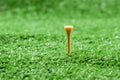 Close up of yellow wood golf tee in green grass at the golf court Royalty Free Stock Photo