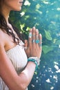 close up of yoga woman hands in namaste gesture with lot of boho style jewelry rings and bracelets outdoor