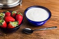 Close up yogurt and strawberries in a blue glass bowl on wooden table Royalty Free Stock Photo