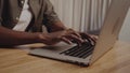 Close up of a Young adult African-American black male typing on laptop. Close up of hands, working from home doing