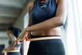 Close-up of young adult black woman in sports clothing. African american girl measuring waist with yellow tape close up Royalty Free Stock Photo