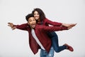 Close-up young african american couple riding back and playing like plane. Royalty Free Stock Photo