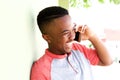 Close up young african man laughing and talking on cell phone Royalty Free Stock Photo