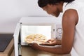 Woman Baking Pizza In Microwave Oven Royalty Free Stock Photo