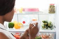 Woman Writing On Spiral Book Near Refrigerator Royalty Free Stock Photo