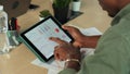 Close up of young afro american businessman at startup meeting looking at charts on tabletPC in modern office. Multi Royalty Free Stock Photo