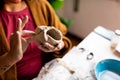 Close up of young artisan woman working with clay with tools, a manual work that requires craftsmanship and skills, also a hobby