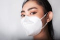 Close up of young Asia woman putting on a medical mask n95 to protect from airborne respiratory diseases as the flu covid-19 PM2.5