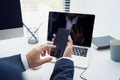 Close-up of a young Asian businessman`s hand holding mobile phone and touching screen on desk in an office. Social networks and Royalty Free Stock Photo