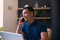 A close up of a young Asian businessman taking a call at his office desk Royalty Free Stock Photo