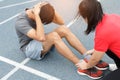 Close up of young asian couple doing sit-ups on the blue running track in stadium Royalty Free Stock Photo