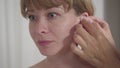 Close-up of young asian-looking woman waiting for doctor to clean ears before acupuncture. Portrait of focused female