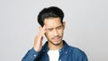 Close up of young asian man doubting while standing over grey background, Portrait of confused handsome asia guy, People