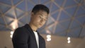 Close up of young asian man in jacket and shirt with interactive wayfinding kiosk