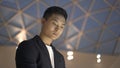 Close up of young asian man in jacket and shirt with interactive wayfinding kiosk