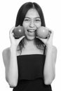 Close up of young Asian teenage girl putting green and red apple near the face Royalty Free Stock Photo