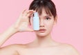 Close up of young asian woman with fresh skin holding a bottle of cream in hand. girl Applying a Cream Bottle Template cosmetic Royalty Free Stock Photo