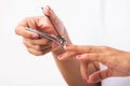 Woman cutting nails on finger using a nail clipper Royalty Free Stock Photo
