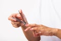 Woman cutting nails on finger using a nail clipper Royalty Free Stock Photo