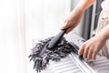 Close up young Asian woman holding dust cleaner mop cleaning suitcase while quarantine Royalty Free Stock Photo