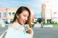 Asian woman shopping an outdoor flea market with a background of pastel bulidings and blue sky. Royalty Free Stock Photo