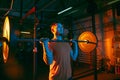 Close up young athletic man training with barbell in gym in mixed neon light. Royalty Free Stock Photo