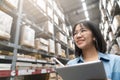 Close up of young attractive asian woman, auditor or trainee staff work stocktaking inventory in warehouse store by computer Royalty Free Stock Photo