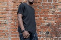 Young attractive dark-skinned man in black T-shirt on red bricked background. Royalty Free Stock Photo