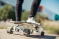 Close up of young attractive man riding longboard in the park.