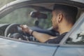 Close up of young attractive man sitting in the black car. Royalty Free Stock Photo