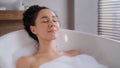 Close-up young attractive relaxed woman lying in hot foam bath with eyes closed resting relaxing in bathroom happy Royalty Free Stock Photo