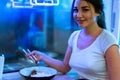 Close up of young attractive woman eating asian food with chopsticks at cafe. Royalty Free Stock Photo