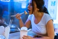 Close up of young attractive woman eating asian food with chopsticks at cafe. Royalty Free Stock Photo