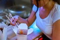 Close up of young attractive woman eating asian food with chopsticks at cafe. Royalty Free Stock Photo