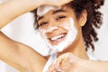 Close up of young beautiful darkskinned woman cleaning her skin with facial wash Royalty Free Stock Photo