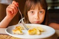 Close up young beautiful girl eating cheesecakes for breakfast. Funny facial expression Royalty Free Stock Photo