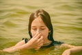 A girl swims in the river. Close up of young beautiful girl in water Royalty Free Stock Photo