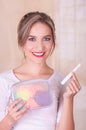 Close up of a young beautiful smiling woman holding a menstruation cotton tampon in her hand and a colorful purse inn Royalty Free Stock Photo