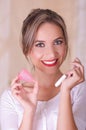 Close up of young beautiful smiling woman holding a menstruation cotton tampon in one hand and with her other hand a Royalty Free Stock Photo