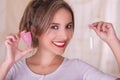 Close up of young beautiful smiling woman holding a menstruation cotton tampon in one hand and with her other hand a Royalty Free Stock Photo