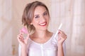 Close up of young beautiful smiling woman holding a menstruation cotton tampon in one hand and with her other hand a Royalty Free Stock Photo